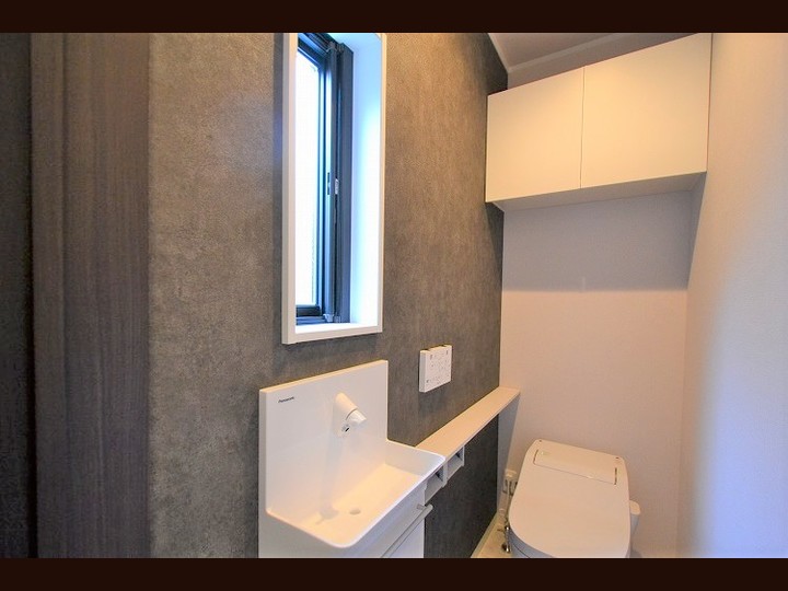 １F　トイレ 側面の１面をアクセントクロスに貼り分けすることで素敵なトイレ空間となっています。