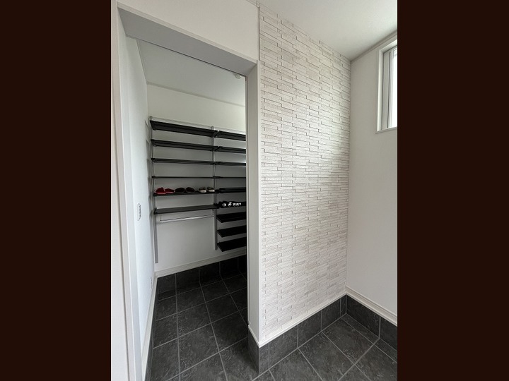 玄関ホールのエコカラットで装飾された壁の裏にはオープンタイプの玄関クロークとなっています。シューズ、コート、傘等がたっぷり収納できます♪